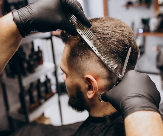 Barber cutting a man's hair with scissors