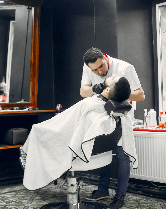 Barber blending a men's fade haircut with clippers 
